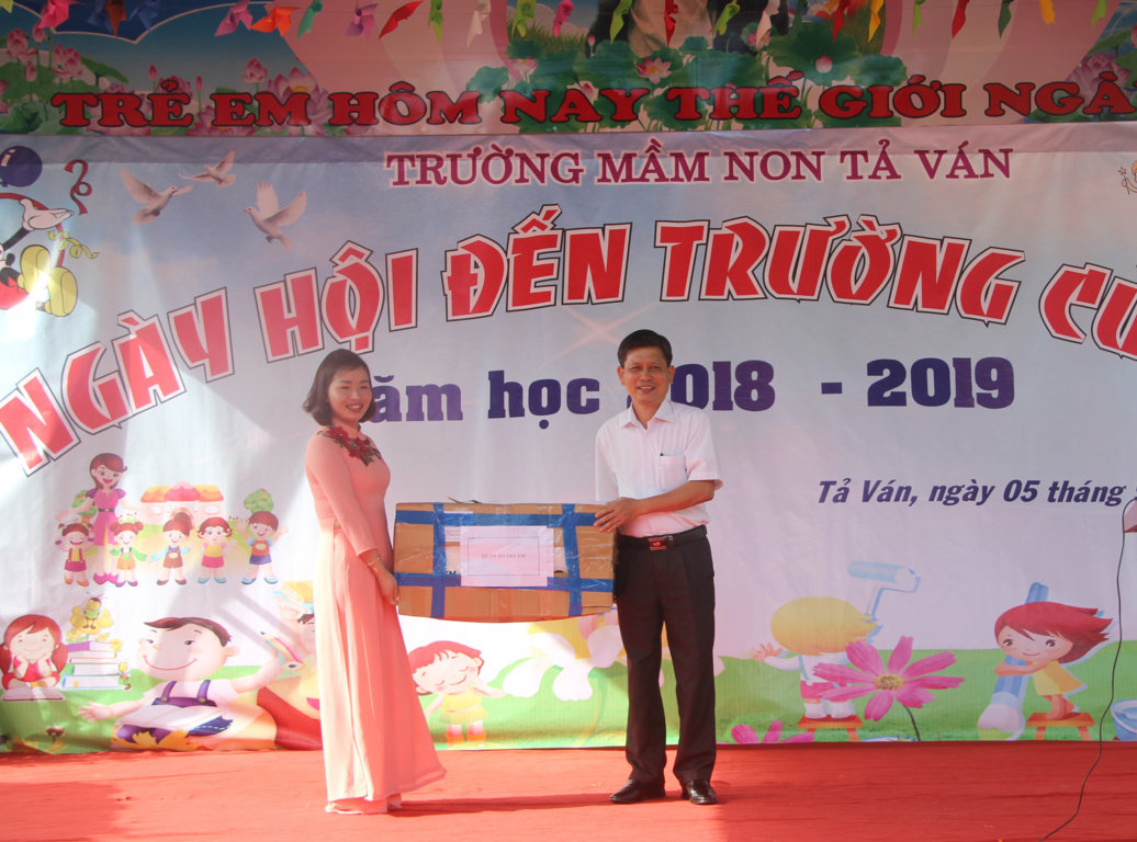Đồng chí Đặng Văn Huynh, Phó Giám đốc Sở Y tế trao quà cho trường Mầm non, xã Tả Ván, huyện Quản Bạ nhân dịp khai giảng năm học mới 2018 - 2019