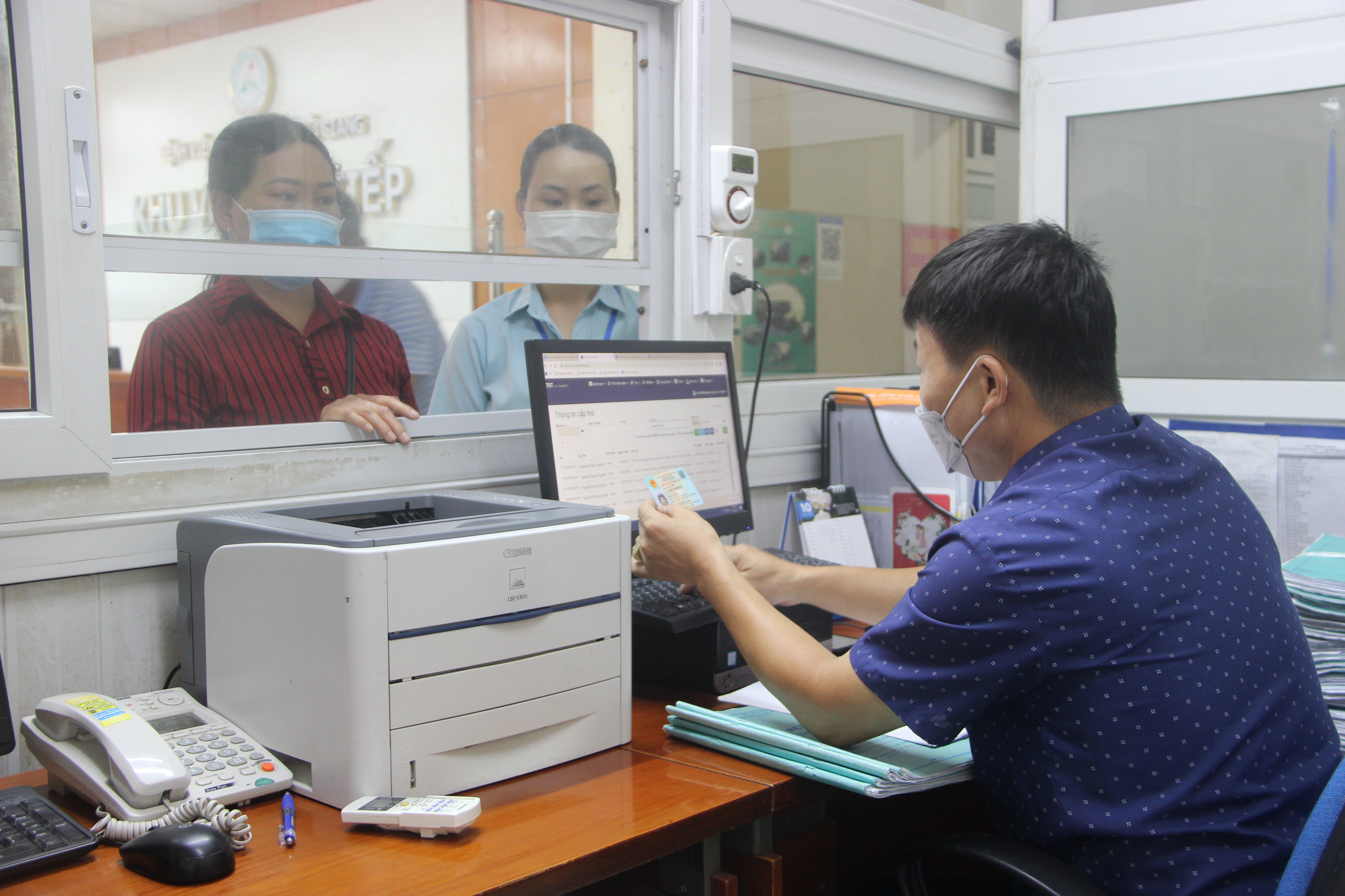Cán bộ BHXH tra cứu thông tin thẻ BHYT bằng CCCD tại BVĐK tỉnh.