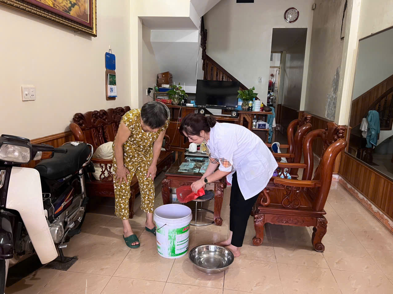 Cán bộ Y tế phường Nguyễn Trãi hướng dẫn người dân xử lý nước sinh hoạt sau mưa bão
