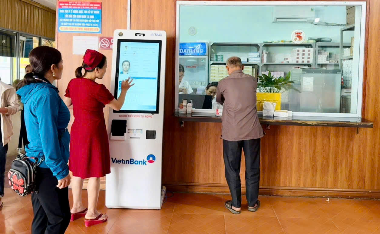 Nhân viên y tế hỗ trợ người dân thực hiện đăng ký khám.