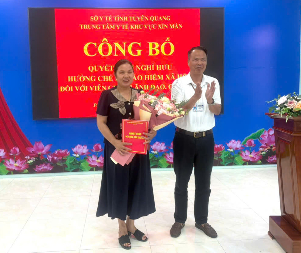 Đ/c Vương Thanh Nguyên, Giám đốc Trung tâm Y tế khu vực Xín Mần trao Quyết định nghỉ hưu cho đồng chí Nguyễn Thị Giang.